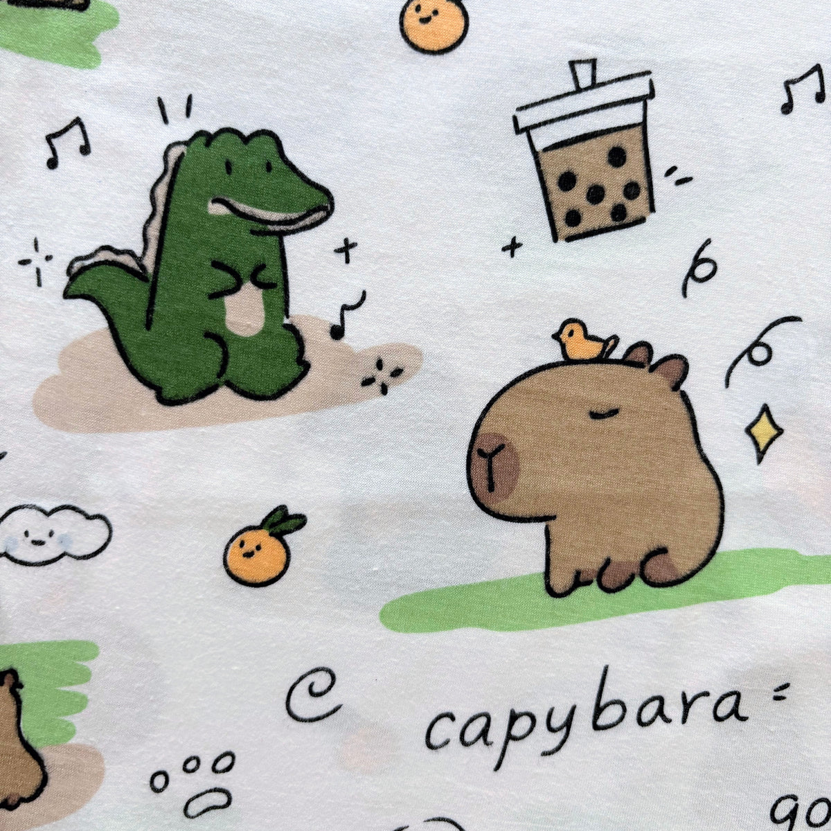 Close-up of the Capybara, Dinosaur, Bubble Tea and Orange print on the Cozy Capybara Cotton Co-ord Set.