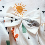Close up of the sun print and bow on the Sunny Cactus Cotton Frock.